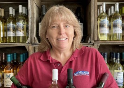 Cindy holding award-winning bottles of wine